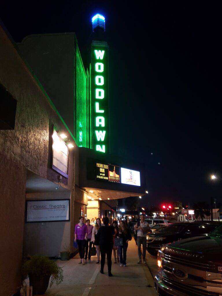 The Woodlawn Theater neon marquee lit at night